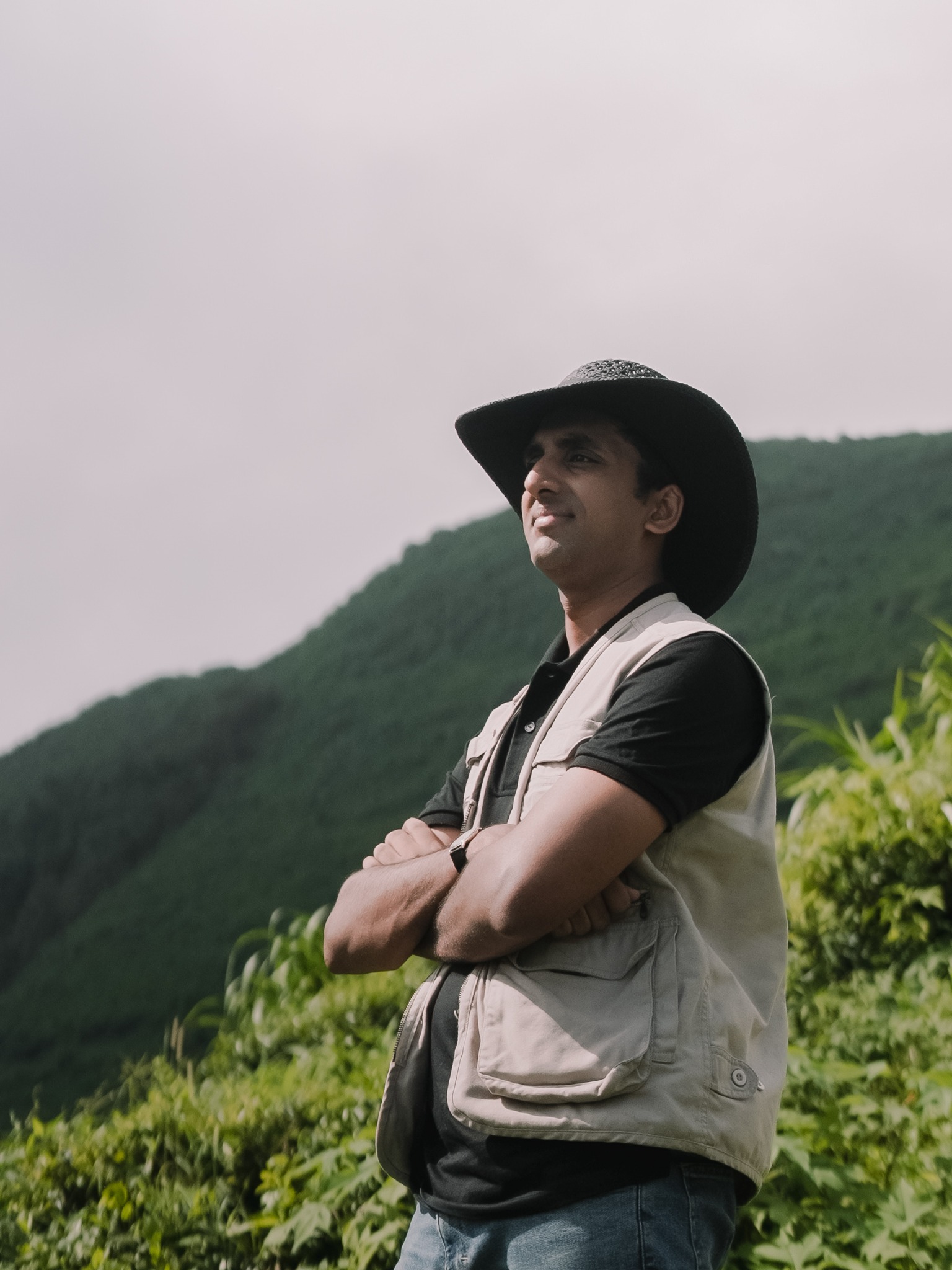 Sparsh standing among tea bushes in the hills
